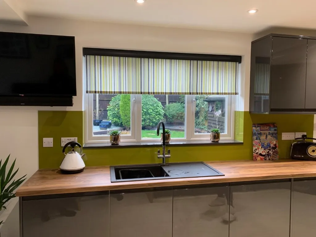 Striped roller blind above a kitchen sink with lime green splashback